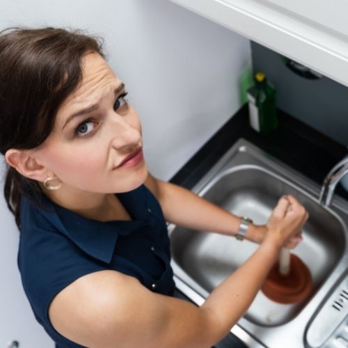 Frau mit Pümpel am Waschbecken